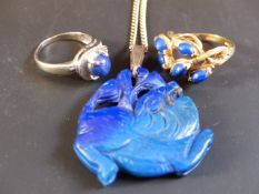 A carved Lupis Lazuli pendant on chain. A Lupis Lazuli 9ct gold dress ring and a 14k blue stone