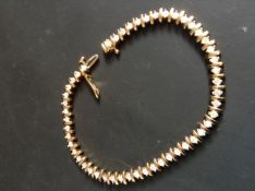 A 9ct gold diamond set tennis bracelet. 18cm long