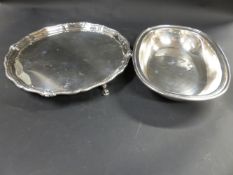 A silver salver with embossed rim. On three short pad feet. London 1932. 22ozs. Together with a