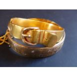 A yellow precious metal stiff buckle bracelet. 15grams. A 9ct gold wax filled stiff bracelet set