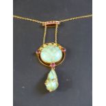 An Art Nouveau green jadite and pink gem stone openwork pendant on chain