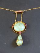 An Art Nouveau green jadite and pink gem stone openwork pendant on chain