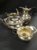 A silver matched four piece tea set with gadroon rims. Embossed classical designs. London 1899,