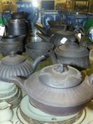 A group of antique and later black basalt Wedgwood tea pots, a silver mounted jug and other pieces