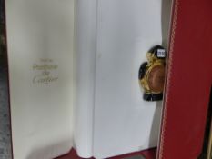 A large cased Panthere de Cartier scent bottle in red and gilt case with integral backgammon board.