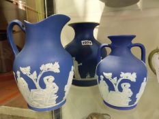 Three pieces of Wedgwood blue Jasper ware to include a baluster vase. 21cm high, a model of the