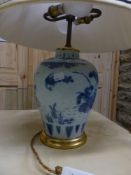 An antique blue and white Delft ware vase decorated with Chinese style motifs mounted as a lamp.