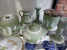 Six pieces of Wedgwood green Jasper ware to include a pair of candlesticks, two teapots, a biscuit