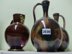 A pair of Wedgwood pottery ewers with streaked glaze and a similar jug with gilt mask spout