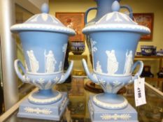 A pair of Wedgwood blue Jasper ware twin handle covered urns of campagna shape on square bases. 31cm