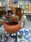 A Wedgwood Rosso Antico jug, three other terracotta pottery pieces, a teapot, a creamer and