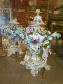 A pair of German Meissen style covered vases with twin scroll handles, applied winged putti to