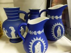 Four Wedgwood blue Jasper ware jugs of varying design.