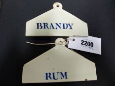 Two antique Wedgwood cream ware liquor bin labels Brandy and Rum in blue. 14cm and 13cm wide