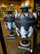 A pair of Wedgwood black Jasper ware twin handle urns of classical shape. 21.5cm high.