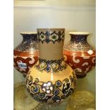 A pair of early 20th Century squat baluster form art pottery vases with scrolling decoration and a