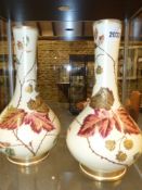 A pair of Wedgwood pottery bottle shape vases with polychrome and gilt bramble berry decoration.