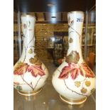 A pair of Wedgwood pottery bottle shape vases with polychrome and gilt bramble berry decoration.