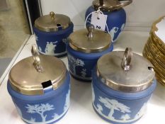 Five Wedgwood blue Jasper ware jam pots with metal covers one with swing handle.