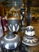 Four pieces of black Jasper ware to include a lamp base, a covered match safe/striker, a covered