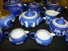 A collection of various Wedgwood blue Jasper ware teapots, covered sugar bowls and cream jugs