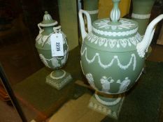 Two Wedgwood green Jasper ware covered twin handle vases of urn shape on plinth bases. Height of