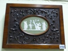 An antique green Jasper ware oval plaque of classical figures with Cupid. Framed in carved walnut