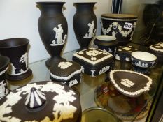 A group of Wedgwood black Jasper ware pieces to include covered boxes, pairs of vases, a jardiniere,