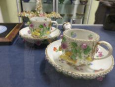 Two Meissen Cabinet cups and saucers with flower encrusted decoration together with a similar