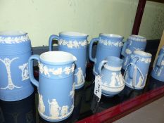 Eight Wedgwood blue Jasper ware jugs to include two sets of three in graduated sizes.