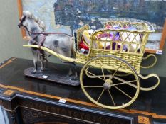 AN INTERESTING TOY MODEL HORSE ON PLATFORM BASE PULLING A WICKER BODIED TWO WHEELED CART.