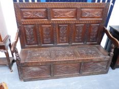 A LARGE 18TH.C.AND LATER OAK PANEL BACK HALL SETTLE WITH BOX SEAT.