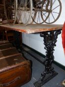 AN ANTIQUE OAK TOPPED TABLE WITH CAST IRON SUPPORTS