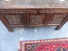AN EARLY 18TH.C.OAK PANEL COFFER WITH SHALLOW CARVED DECORATION AND TALL STYLE FEET.