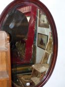 A LARGE OVAL WALL MIRROR