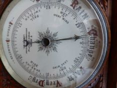 A VICTORIAN GOTHIC REVIVAL OAK CASED ANEROID BAROMETER.