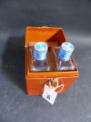 A PAIR OF ENAMEL TOP CUT GLASS BOTTLES IN FITTED LEATHER CASE