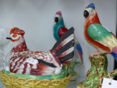 TWO STAFFORDSHIRE POTTERY FIGURES OF PARROTS WITH POLYCHROME DECORATION AND A SIMILAR PERIOD HEN