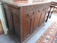 AN 18TH.C.AND LATER OAK COFFER OF UNUSUALLY DEEP FORM WITH PLANKED TOP OVER CARVED FRIEZE AND TRIPLE