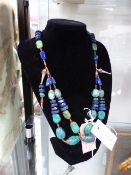 A TRIBAL WHITE METAL NECKLACE FORMED OF LARGE BEADS OF TURQUOISE AND LAPIS LAZULI.