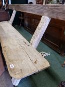 AN ANTIQUE RUSTIC PINE X-FRAMED SETTLE. W.300cms.