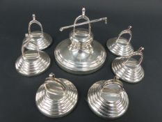 SIX HALLMARKED SILVER MENU/PLACECARD HOLDERS OF STIRRUP FORM TOGETHER WITH A LARGER EXAMPLE WITH