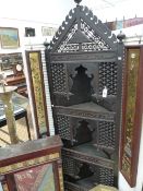 A CARVED EASTERN FLOOR STANDING CORNER CABINET WITH THREE NICHE SHELVES. CALLIGRAPHIC