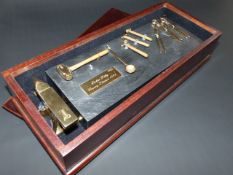 AN UNUSUAL SET OF HALLMARKED SILVER GILT MINIATURE FARRIER/BLACKSMITH TOOLS AND ANVIL MOUNTED ON A