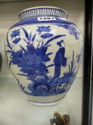 A JAPANESE ARITA BLUE AND WHITE BALUSTER FORM VASE DECORATED WITH FIGURES AND FOLIAGE. 20CM HIGH