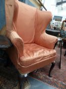 A 19TH.C.WING BACK ARMCHAIR ON TALL CABRIOLE FORELEGS AND SWEPT REAR FEET.