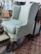 AN EARLY 19TH.C.WING BACK ARMCHAIR ON SQUARE CHAMFERRED FORELEGS UNITED BY STRETCHER.
