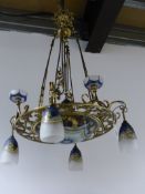 A BRASS FRENCH ART DECO STYLE CHANDELIER HAVING POLYCHROME GLASS SHADES AND CENTRAL PLAFONNIER.