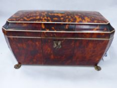 A LARGE REGENCY TORTOISESHELL INLAID SARCOPHAGUS FORM TEA CADDY WITH FITTED INTERIOR.