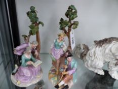TWO CONTINENTAL POLYCHROME FIGURAL GROUPS EACH OF A MAID AND COMPANION BENEATH A TREE WITH IMPRESSED